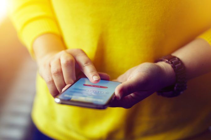 Woman signs up to banking with her mobile phone in the office